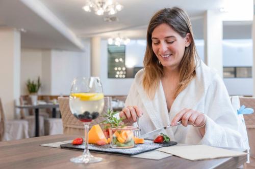 a woman sitting at a table with a glass of wine at Hotel Delle Terme Santa Agnese in Bagno di Romagna