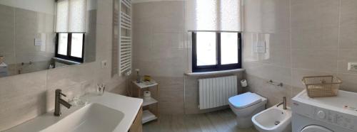 a white bathroom with a sink and a toilet at La Casa di PAT in Campobasso