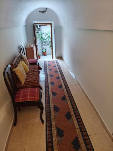 a living room with a couch and a rug at House in the old town with view in Gjirokastër
