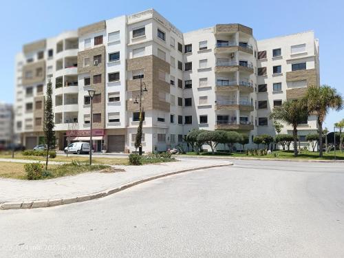 an empty street in front of a large apartment building at Appart Haut Standing, Très Calm à Nouaceur, Parking, Piscine, à 4min de l'Aéroport in Casablanca