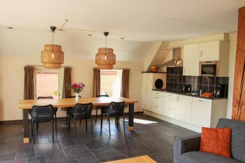 a kitchen with a dining room table and chairs at Luxe vakantiehuis in Friesland in Joure