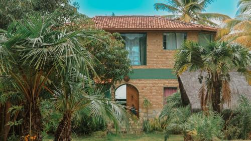 a house with palm trees in front of it at Casa Del Mar in Marau
