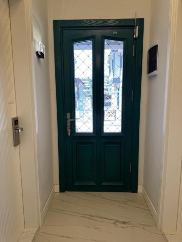 a green door with a window in a hallway at Dione Bozcaada in Bozcaada