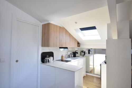 une cuisine avec comptoirs blancs et lucarne dans l'établissement Cote d'argent - Hossegor en bordure du lac et à côté du joli parc, à Soorts-Hossegor