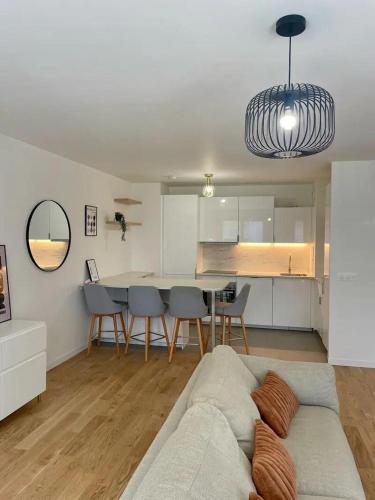 un salon avec un canapé et une table dans l'établissement Coté Paname large 2 bedroom apartment with parking space, à Clichy