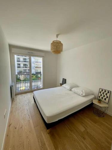 une chambre blanche avec un grand lit et une fenêtre dans l'établissement Coté Paname large 2 bedroom apartment with parking space, à Clichy
