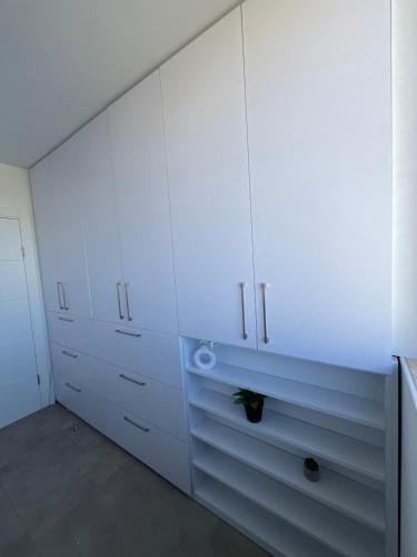 a white kitchen with white cabinets at Boutique apartment in Rishon LeẔiyyon