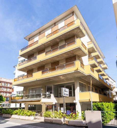 un edificio giallo e bianco con un cartello di fronte di Hotel Ischia a Rimini