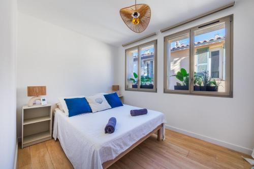 a bedroom with a bed and two windows at Village house pkg, air conditioning elevator in Cassis