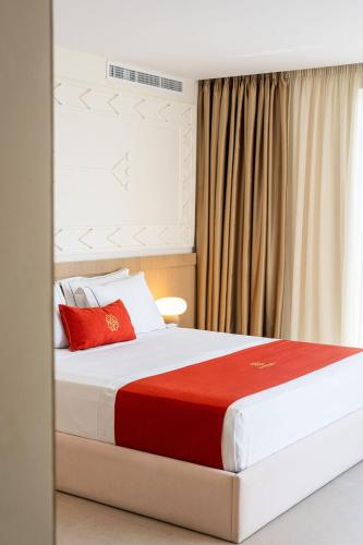 a bedroom with a large bed with red pillows at Hotel Skanderbeg in Golem