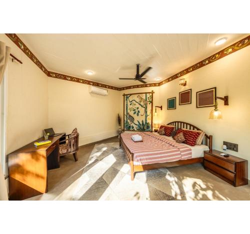 a living room with a bed and a desk at Jungle Ghar in Pachmarhī