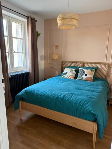 une chambre avec un lit avec une couette bleue dans l'établissement Chez Auguste, à Chaumont