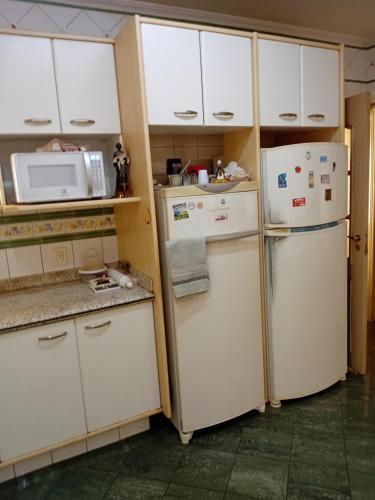 a kitchen with white cabinets and two refrigerators at Casa dos Fraga Araújo in Ribeirão Preto