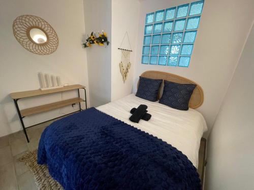 une chambre avec un lit avec une couverture bleue et une fenêtre dans l'établissement T2 Jardin Privé, Côté Bleue, Bord de mer, à Sausset-les-Pins