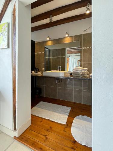 La salle de bains est pourvue d'un grand miroir et d'un lavabo. dans l'établissement LE PRESBYTÈRE DE LA CITE ROYALE DE LOCHES, à Loches