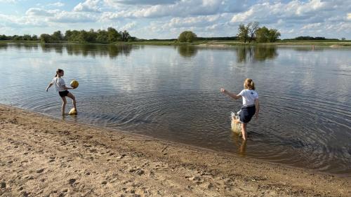 two women are playing in the water on the beach at Ferienhaus St. Johannis in Werben