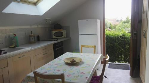 une cuisine avec une table avec une assiette dessus dans l'établissement Appartement dans maison avec jardin privé, à La Terrasse