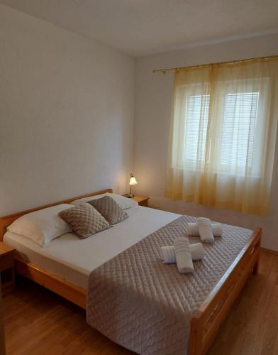 a bedroom with a large bed with towels on it at Apartments Gojevic in Bol