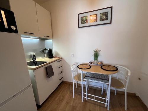 - une petite cuisine avec une petite table et des chaises dans l'établissement Studio proche promenade des anglais, à Nice