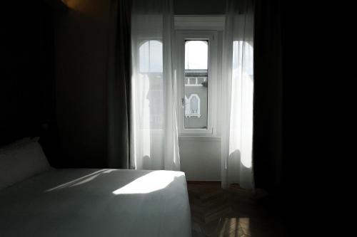 a bedroom with a bed and an open window at Hotel RossoVino Milano in Milan