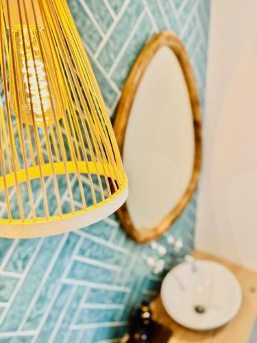 a lamp with a mirror next to a sink at Glamour Apartments in Figueira da Foz