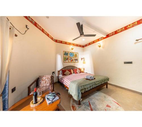 a bedroom with a bed and a chair at Jungle Ghar in Pachmarhī