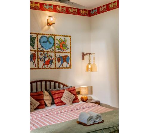 a bedroom with a bed and a picture on the wall at Jungle Ghar in Pachmarhī