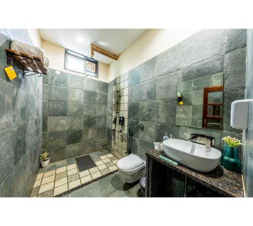 a bathroom with a sink and a toilet at Jungle Ghar in Pachmarhī
