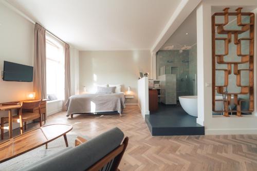 a bedroom with a bed and a bathroom with a tub at Boutique Hotel De Witte Dame in Abcoude