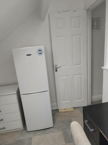 a white refrigerator in a kitchen with a door at Balfour Street in Bradford
