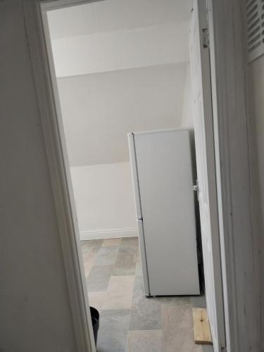 a white refrigerator in a room with a tile floor at Balfour Street in Bradford