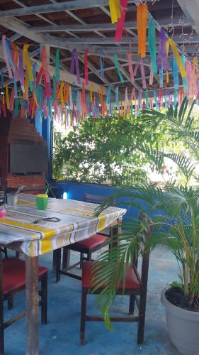 Una mesa con banderas de colores colgando del techo. en Pousada vitoria praia de serrambi-pe, en Ipojuca
