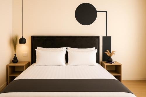 a bedroom with a black and white bed with white pillows at PROMO Elegant Apartments NEW - Colorful by the sea in Durrës
