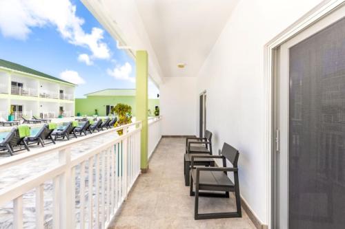 a balcony of a resort with chairs and tables at Ocean Breeze Resort in NCA