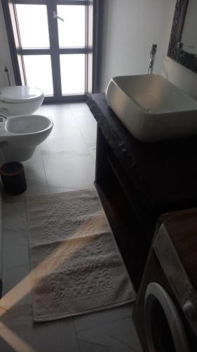a bathroom with a sink and two toilets at La Piccola Corte da Anita in Tortolì
