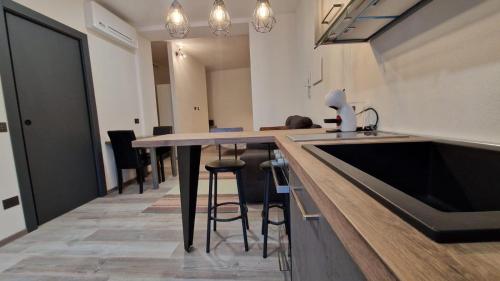 a kitchen with a counter with a sink and stools at La Piccola Corte da Anita in Tortolì