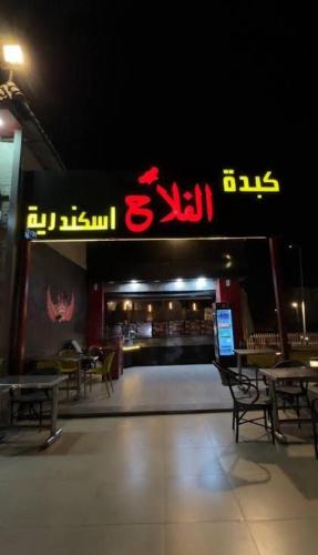 a restaurant with tables and chairs and a sign at فيلا دوبلكس في العين السخنة في قرية بلو باي أسيا عروس السخنة in Ain Sokhna