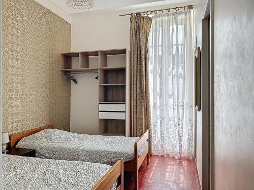 une chambre avec deux lits et une fenêtre dans l'établissement La Vallonnaise, à Vallon-Pont-dʼArc