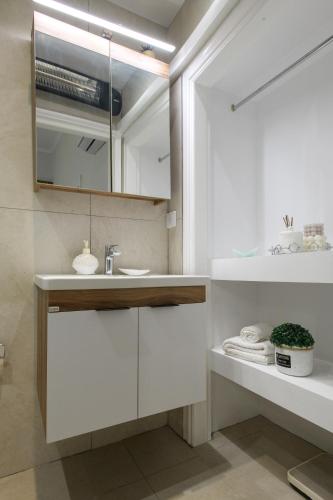 a bathroom with a sink and a mirror at Liston Suites Anastasia in Corfu