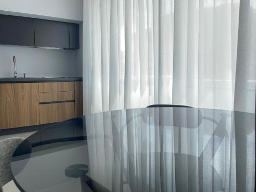 a kitchen with a shower curtain and a table at OMÍ Aparthotel in Caserta