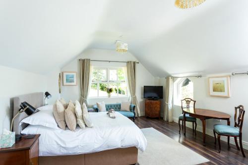 a bedroom with a bed and a desk and a window at The Loft, Apple Lodge & Blossom Lodge in Macroom