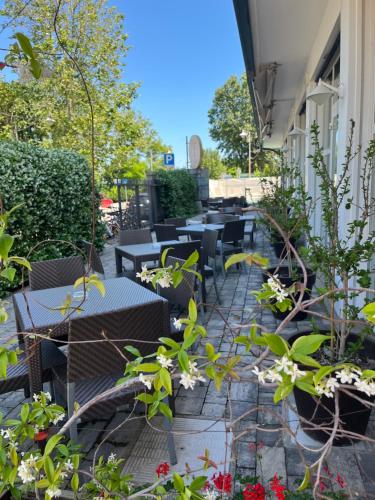a patio with tables and chairs and plants at Hotel Bikini in Rimini