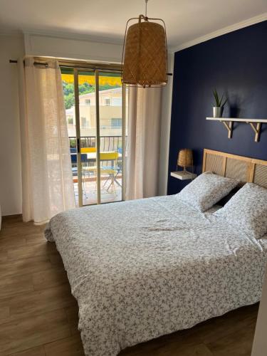 une chambre avec un lit avec un mur bleu dans l'établissement Maggie, à Menton