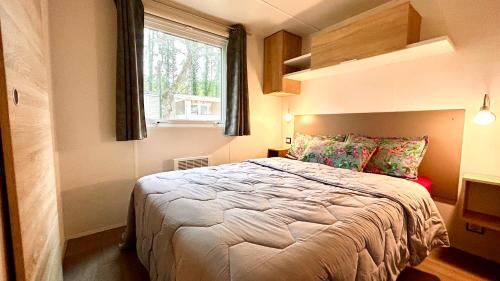 une chambre avec un grand lit avec une fenêtre dans l'établissement MOBIL-HOME HAUT DE GAMME - PROCHE MER - 3 Chambres - Dressing, à Piriac-sur-Mer