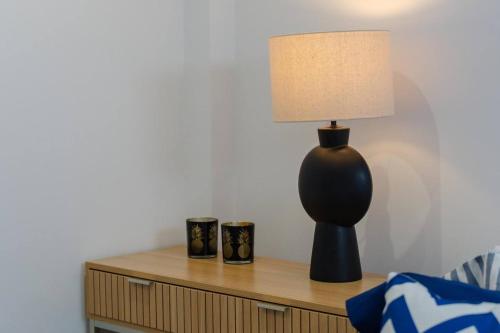 a lamp sitting on a table next to a bed at Tiny House Casa Michelle in Portimão