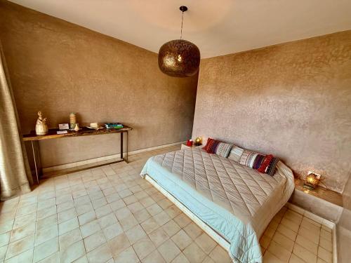 a bedroom with a bed and a table at Kasbah Oum Rabia in Boulaouane