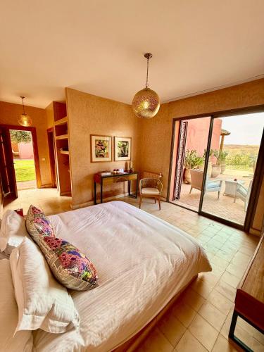 a bedroom with a large bed and a patio at Kasbah Oum Rabia in Boulaouane