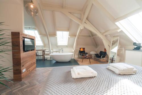 a bathroom with a bed and a tub in a room at Boutique Hotel De Witte Dame in Abcoude