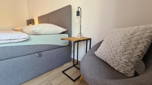 a bedroom with a bed and a chair and a table at Brne Family House in Postojna