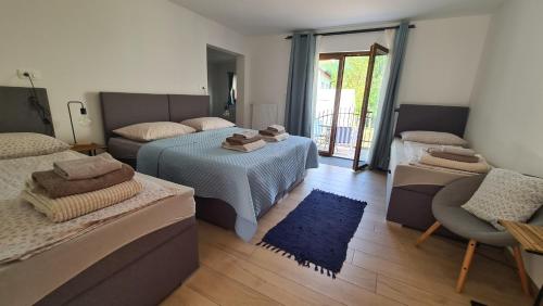 a living room with two beds and a blue rug at Brne Family House in Postojna